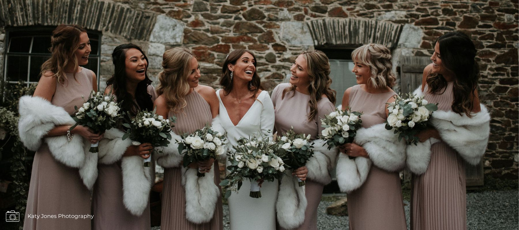 White winter bridal bouquets and bridesmaids holding flower posies of ranunculi's, veronica, eucalyptus and roses.