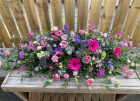 Casket sprays | Funeral Tributes | Bright pink & purple coffin spray