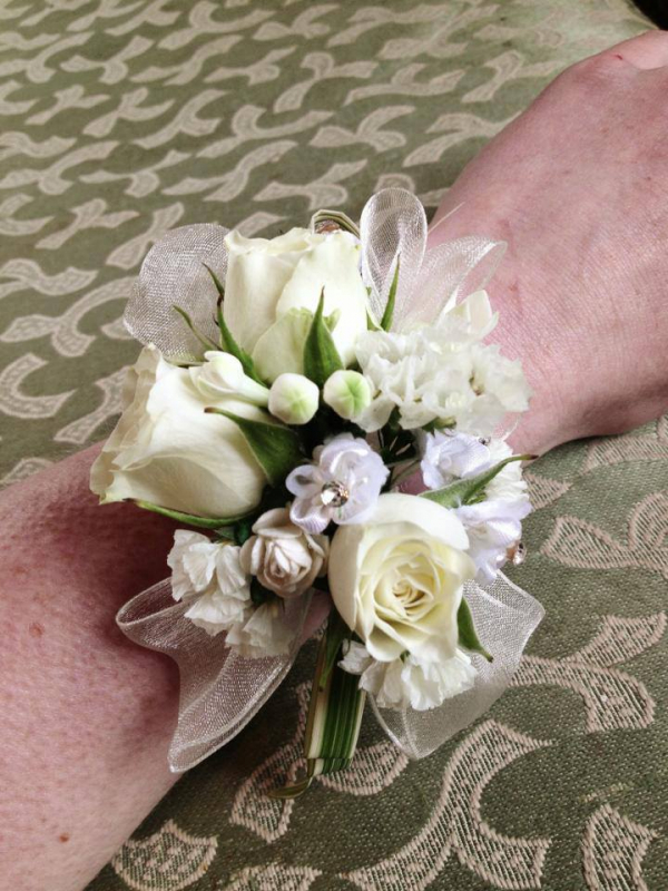 Cream and white flowers with ribbon on a wrist corsage